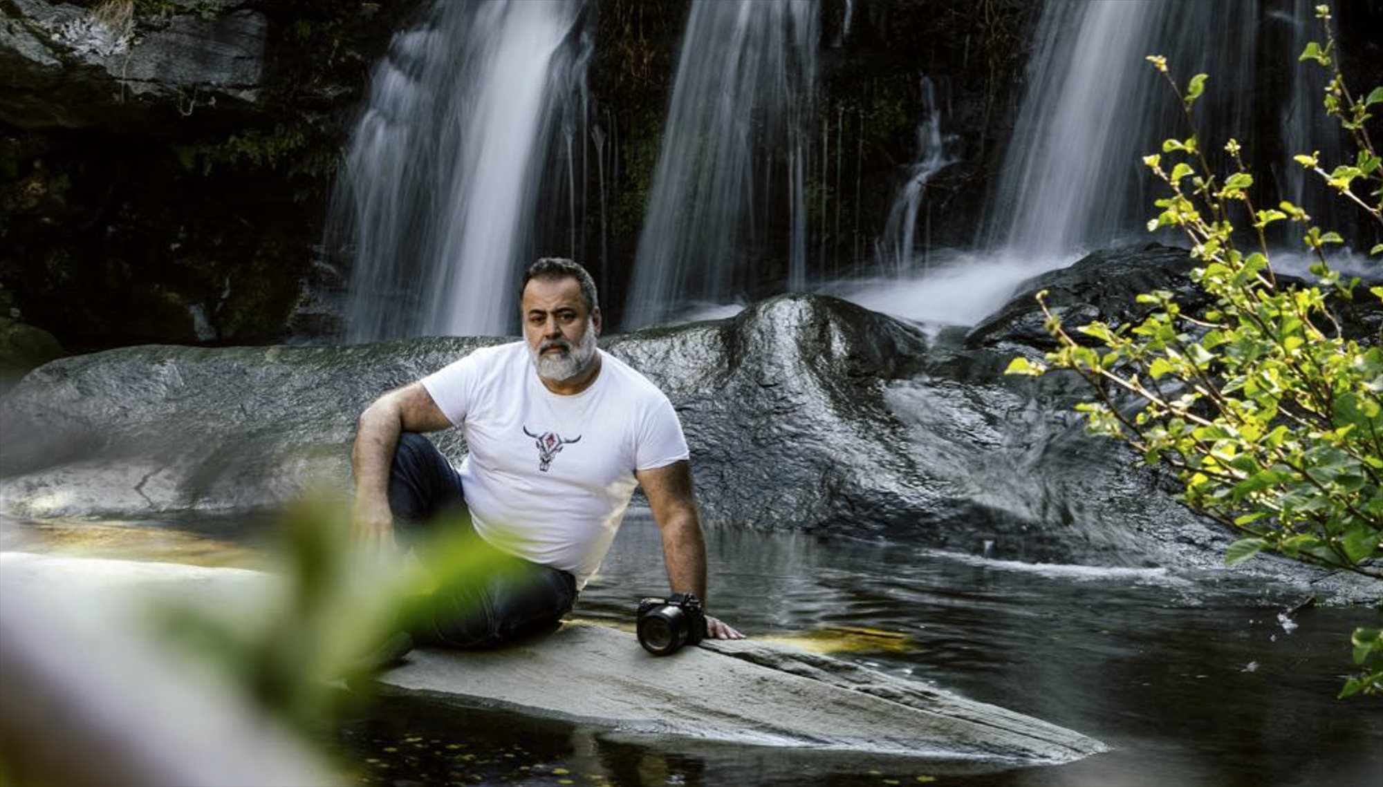Charis Savvides with his camera beside a waterfall
